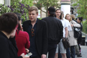WIDZOWIE PRZED TEATREM POLSKIM W POZNANIU - NA PIERWSZYM PLANIE MŁODY MĘŻCZYZNA W MARYNARCE